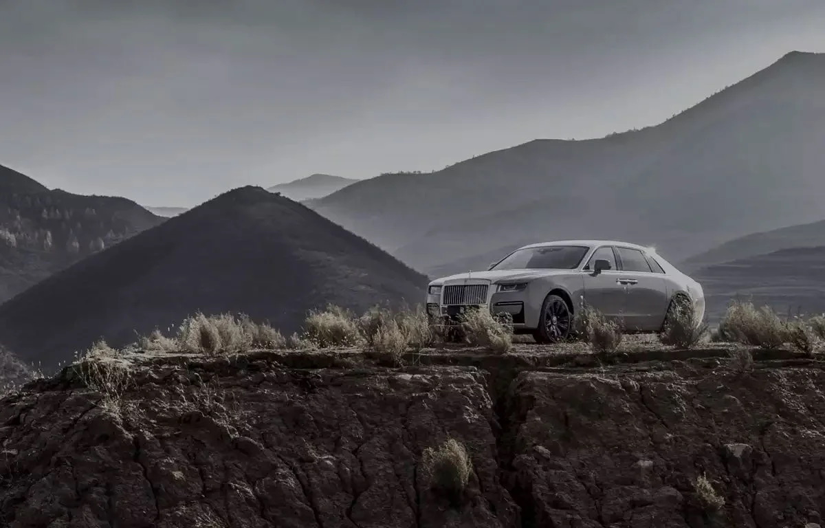 A 2023 Rolls-Royce Ghost in the distance atop a mountain